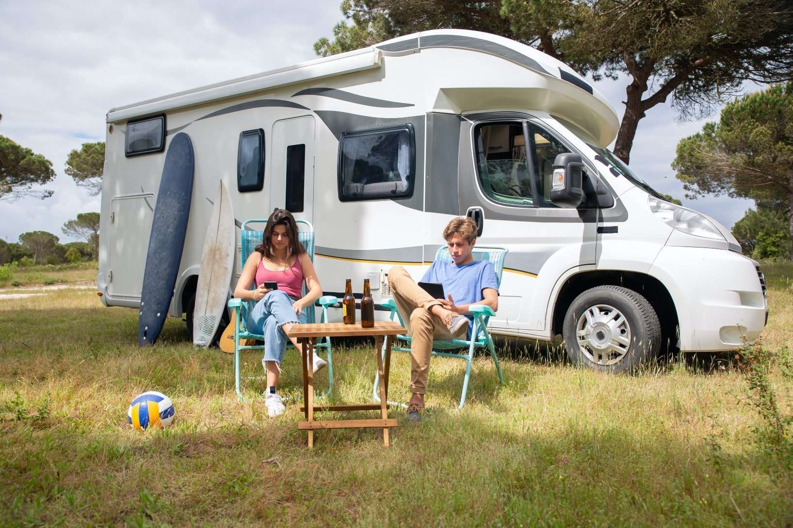 Couple sitting outside of the RV in the Camping chairs