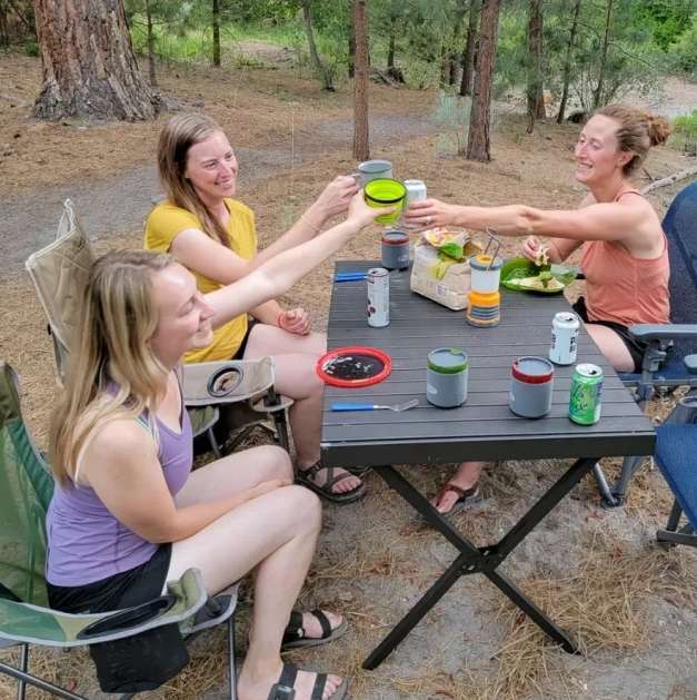friends cheering outside while siting on camping chairs