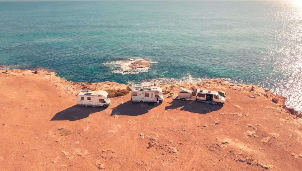 three rvs at the beach shoreline